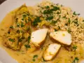 Pyszne curry z kurczakiem w kremowym sosie, podane z kaszą kuskus i posypane natką pietruszki.