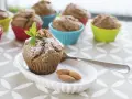 Pyszne muffinki bananowe fit, udekorowane miętą i orzechami, na talerzyku z migdałami.