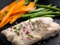 Filet miruny z ziołami i pieprzem, podany z marchewką i fasolką szparagową. Czy miruna jest zdrowa? Tak, to chuda ryba bogata w białko.