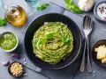 Pyszny, lekkostrawny obiad bez mięsa: spaghetti z domowym pesto, świeżą bazylią i parmezanem. Idealny wybór dla dbających o dietę.
