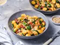 Pyszne gnocchi z pomidorami, szpinakiem i orzeszkami pinii, posypane parmezanem. Idealne danie na szybki obiad.