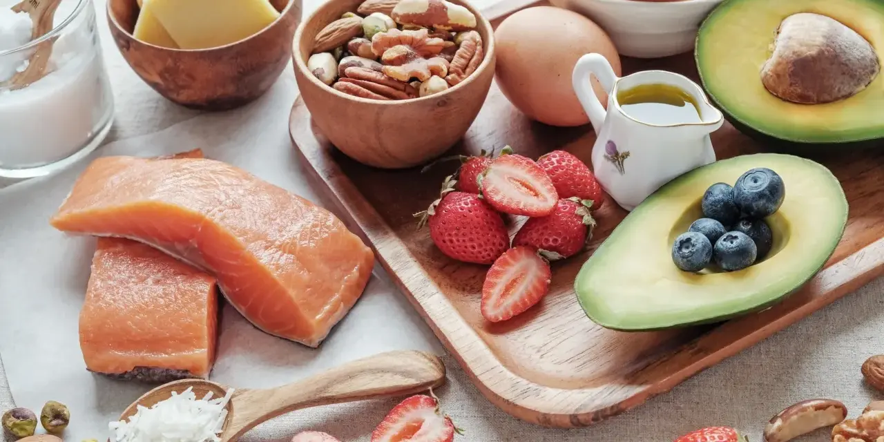 Zdrowe produkty bez węglowodanów: łosoś, awokado, jajka, orzechy, jagody, truskawki i ser. Idealne na keto dietę.