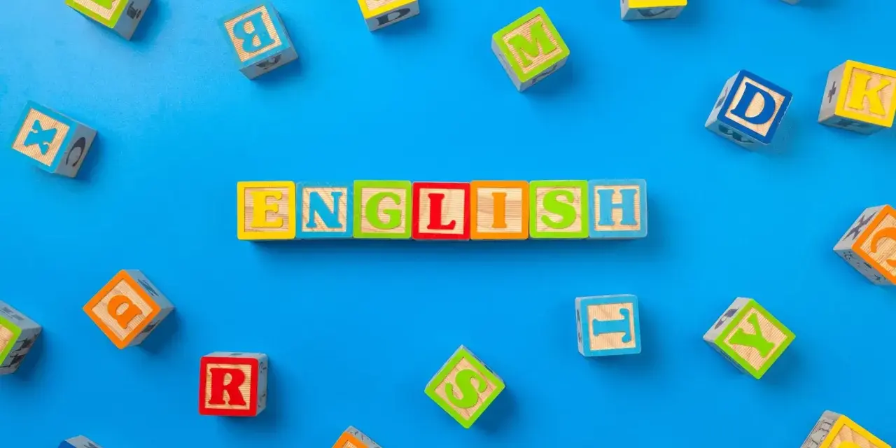 Kolorowe klocki z literami układają się w napis "ENGLISH". To świetny sposób, jak nauczyć dziecko angielskiego przez zabawę.