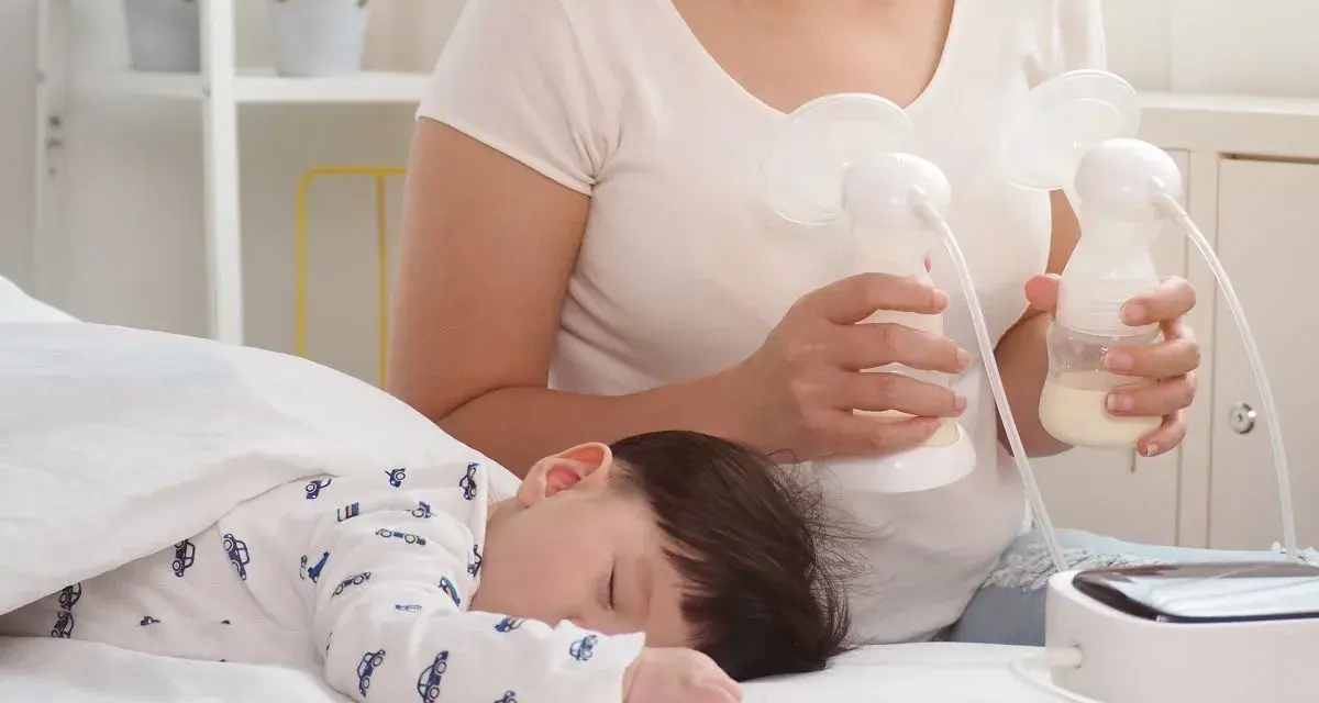 Mama odciąga pokarm 7-5-3, podczas gdy jej dziecko śpi spokojnie.