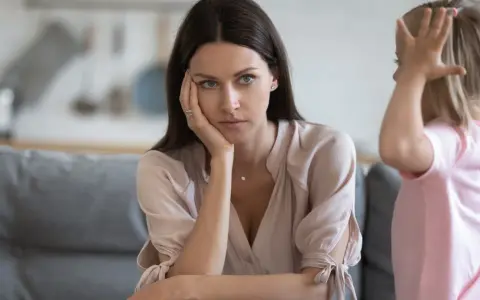 Zmęczona mama zamyślona, podczas gdy jej dziecko 9 lat problemy wychowawcze wywołuje chaos.