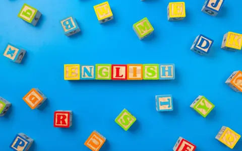 Kolorowe klocki z literami układają się w napis "ENGLISH". To świetny sposób, jak nauczyć dziecko angielskiego przez zabawę.