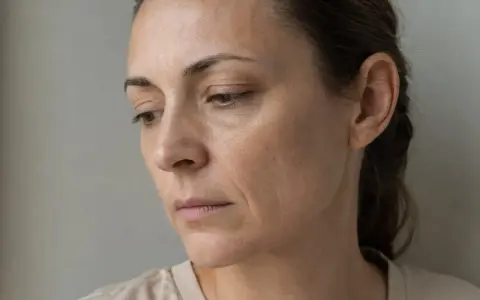 Kobieta z widocznymi zmarszczkami, ukazująca cera po rzuceniu palenia. Skóra jest szara, z przebarwieniami i utratą elastyczności.