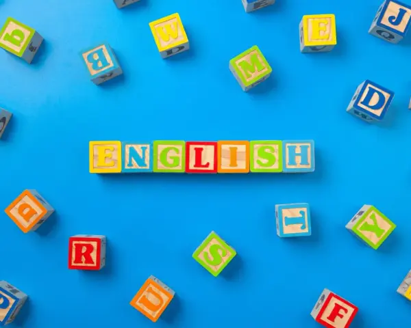 Kolorowe klocki z literami układają się w napis "ENGLISH". To świetny sposób, jak nauczyć dziecko angielskiego przez zabawę.