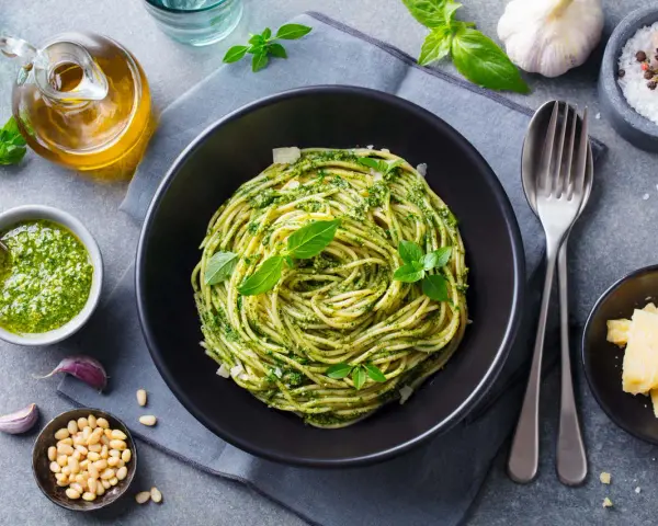 Pyszny, lekkostrawny obiad bez mięsa: spaghetti z domowym pesto, świeżą bazylią i parmezanem. Idealny wybór dla dbających o dietę.