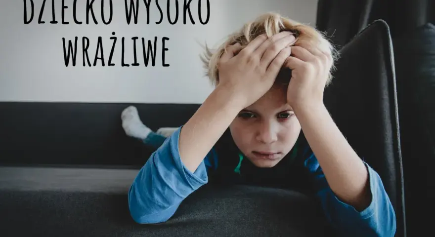 Chłopiec z rękami na głowie, wyrażający smutek. Tekst "Dziecko wysoko wrażliwe" sugeruje, że to objawy dziecka wysoko wrażliwego.