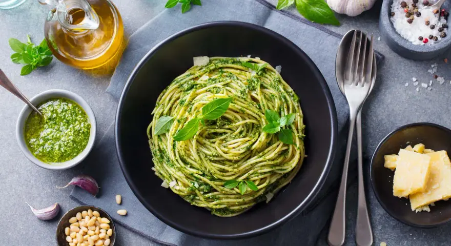 Pyszny, lekkostrawny obiad bez mięsa: spaghetti z domowym pesto, świeżą bazylią i parmezanem. Idealny wybór dla dbających o dietę.