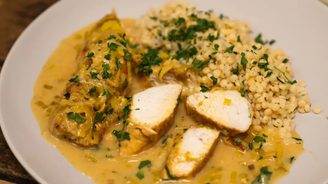 Aromatyczne curry z kurczakiem w kremowym sosie, podane z kaszą perłową i posypane natką pietruszki.