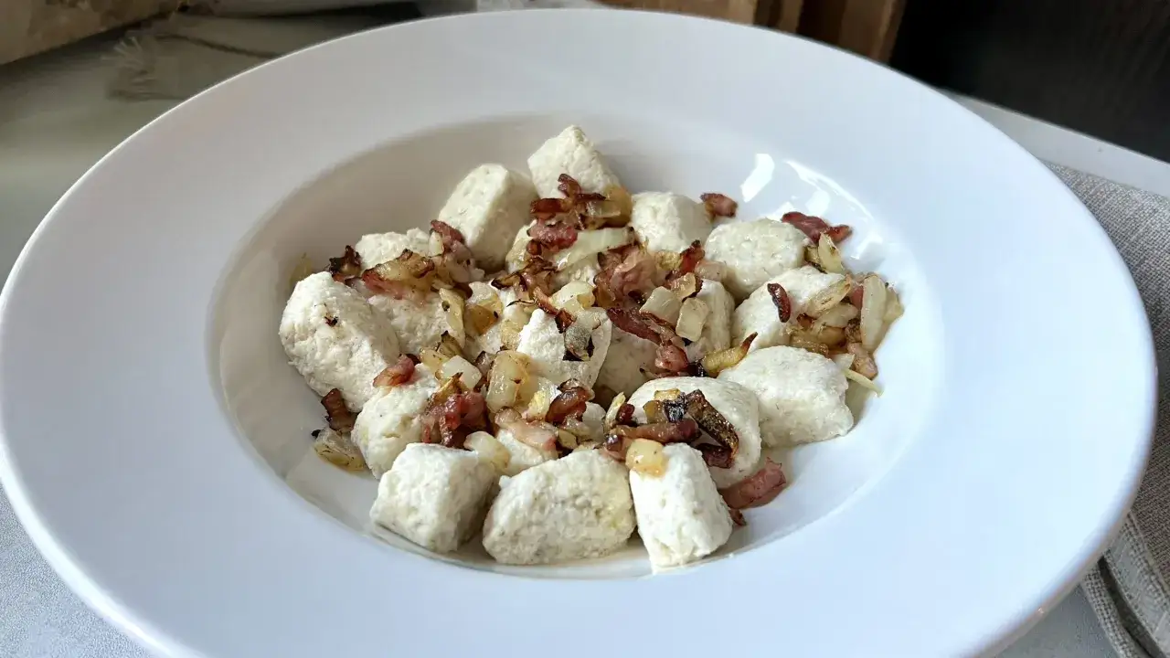 Keto kopytka z mąki migdałowej, podane z chrupiącym boczkiem i cebulką. Pyszne i niskowęglowodanowe danie.